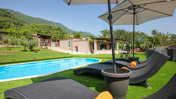 A poolside area with lounge chairs, a hot tub, and a pergola providing shade. - Lovely home in Avella (Avella)