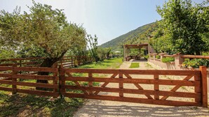 A wooden gate leading to a covered outdoor seating area with a view of a hillside. - Lovely home in Avella (Avella)