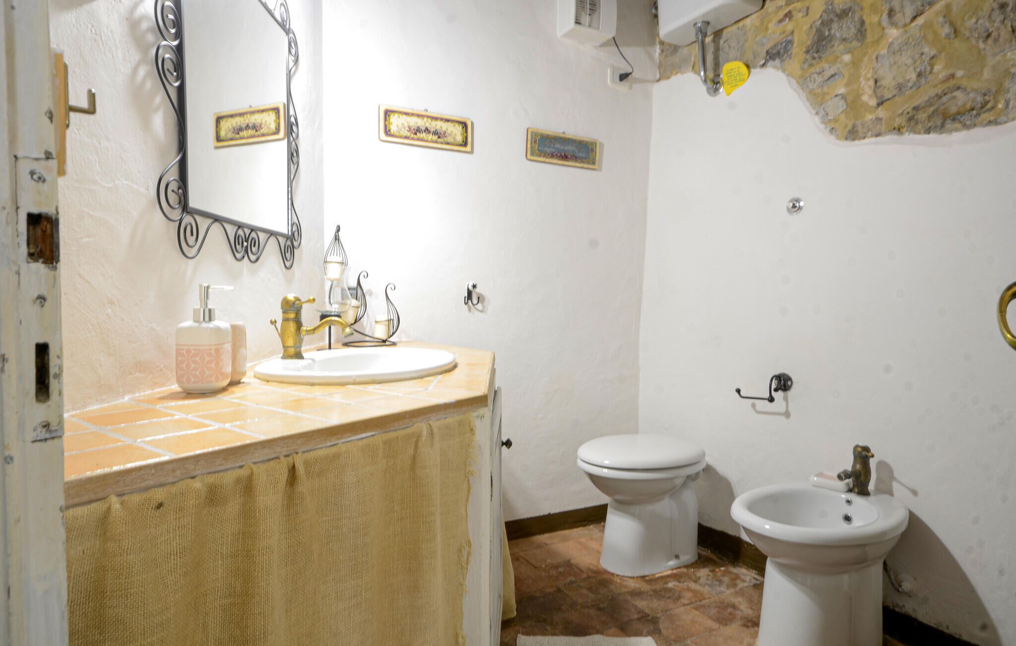 Un baño con lavamanos, dos inodoros y un bidé.