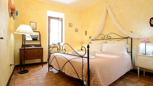 A bedroom with a bed, bedside table, lamp, and a mirror. - Gorgeous apartment in Roccastrada with house a panoramic view (Roccastrada)