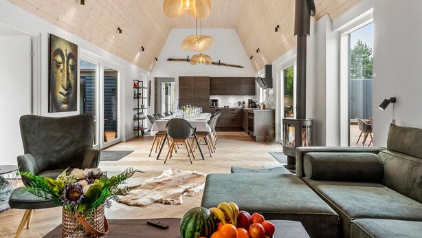 A spacious living room with a high ceiling, a dining area, and a kitchen. - Lovely home in Væggerløse with sauna (Væggerløse)