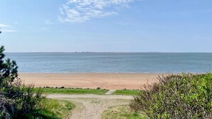 A beach with a clear sky, calm sea, and a distant landmass. - Nice home in Esbjerg V with WiFi (Esbjerg V)