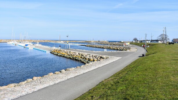 A coastal marina with boats docked, a walking path alongside the water, and a grassy area with a bench. - Cozy home in Hammenhög with WiFi (Hammenhög)