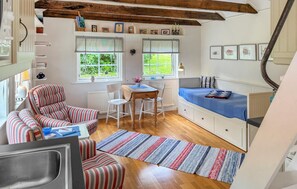Un espace de vie confortable et compact comprenant une cuisine, un coin repas et un lit.