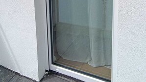 Ein Fenster mit Blick auf ein Gebäude und einen bewölkten Himmel.