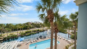 A pool area with lounge chairs and a palm tree.