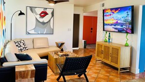 Ein modernes Wohnzimmer mit Sofa, Couchtisch und Fernseher.