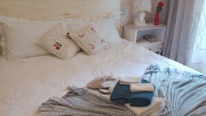 A neatly made bed with pillows, a blanket, and folded clothes. - Authentic B&B Stella's House (Sabbio Chiese)