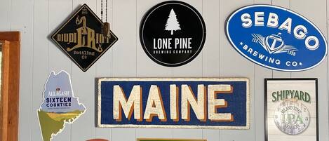 A wall with various brewery logos and signs, including "Lone Pine Brewing Company" and "Sebago Brewing Co."