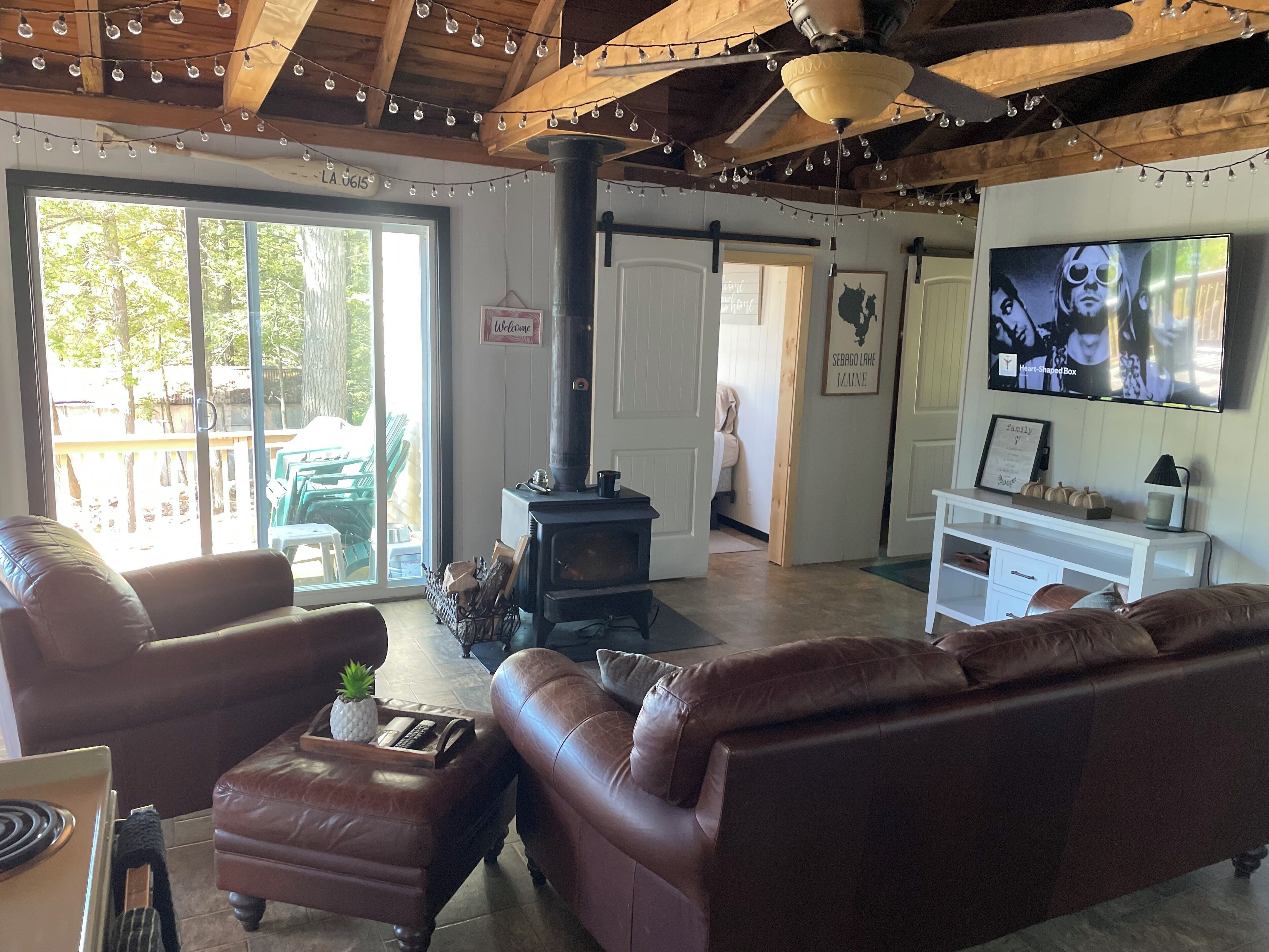 A cozy living room with leather sofas, a fireplace, and a television.