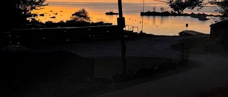 Un sendero que conduce a la orilla de un lago, con vista al atardecer.