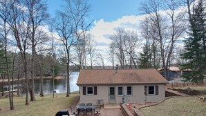 A house with a patio, a dock, and a lake view. - Lake Nokomis  Cozy 2-Bed Getaway for Couples, Families & Outdoor Enthusiasts (Tomahawk)