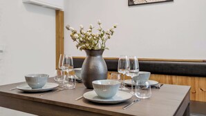 A dining table set with bowls, glasses, and a vase of flowers. - Ranargata - Central Four Bedrooms Apartment A (Reykjavík)