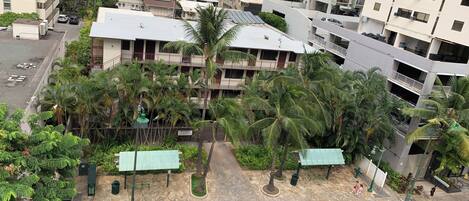 A multi-story building with a rooftop garden, surrounded by other residential buildings.