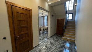 A hallway with marble flooring, wooden doors, and a staircase leading to another level. - Magnolia Family Boutique and Spa (Ismailli)