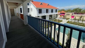 A balcony with a view of a swimming pool and adjacent buildings. - Magnolia Family Boutique and Spa (Ismailli)