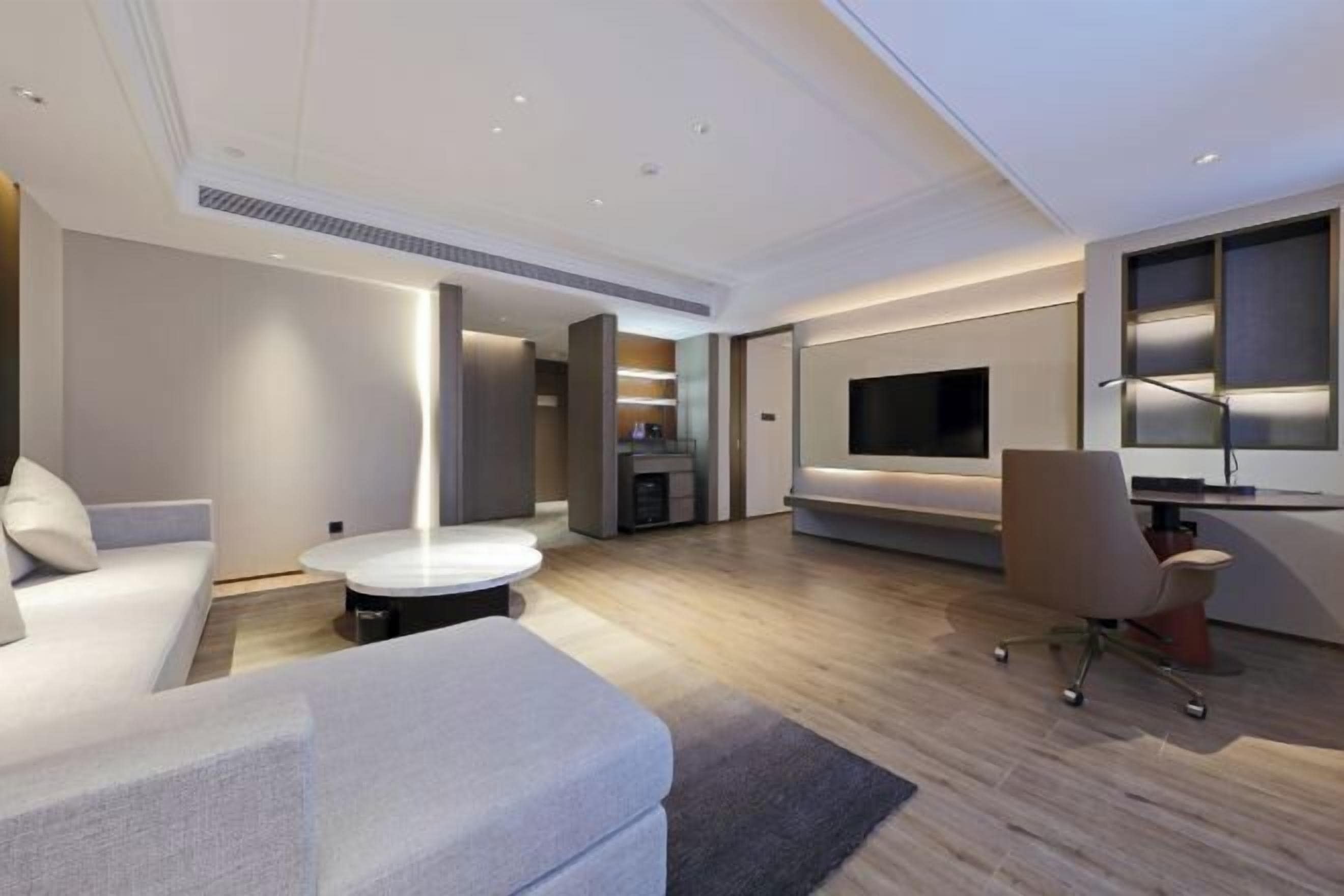 Una sala de estar moderna con un sofá, una mesa de centro, un televisor y una chimenea.