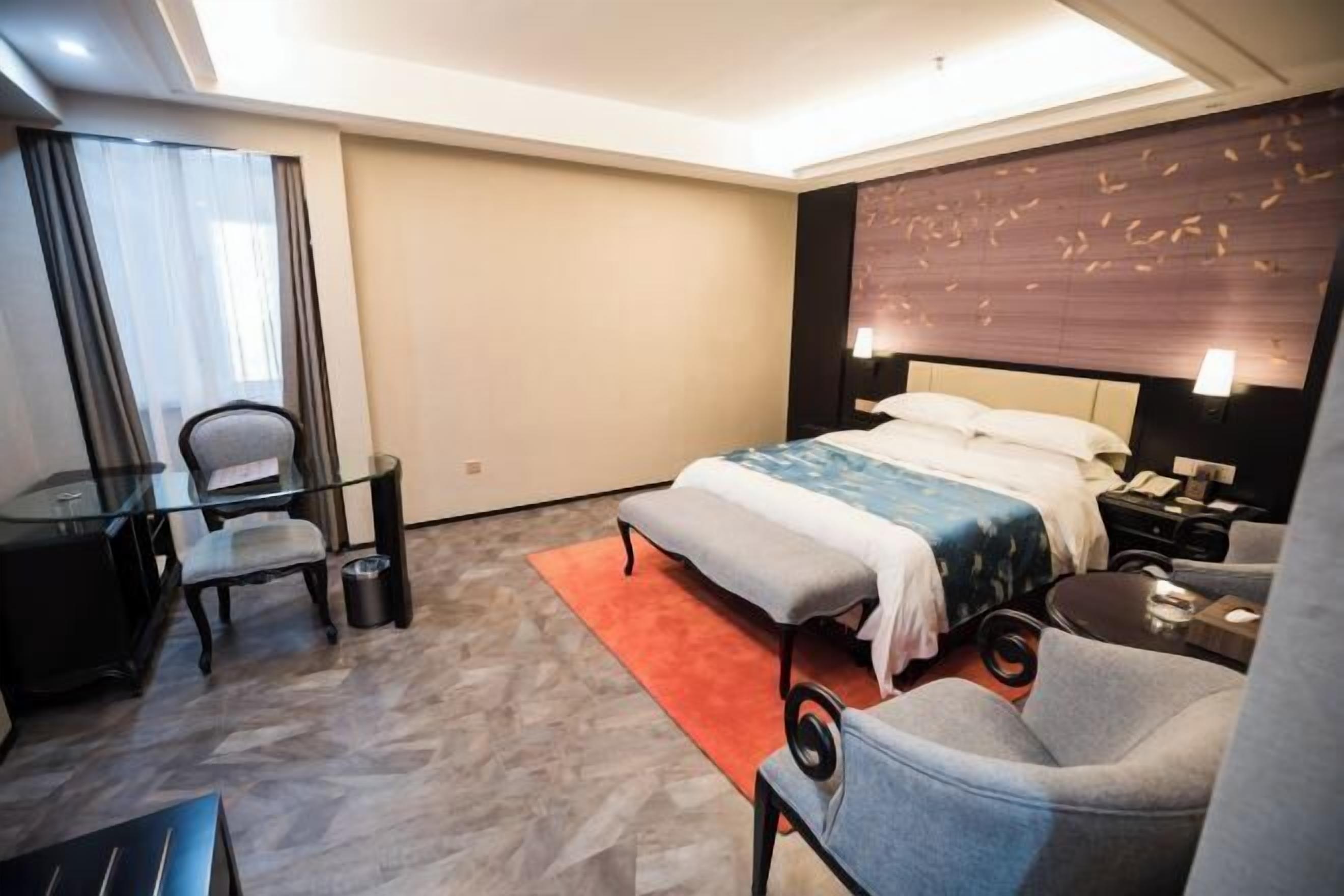 Una habitación de hotel con una cama, un escritorio, una silla y un sofá.