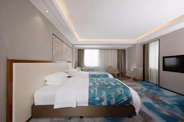 Una habitación de hotel moderna con una cama grande, un escritorio y un televisor.