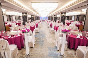 A banquet hall with rows of round tables, each with a tablecloth and chairs. - Xingtai Business Hotel (Jinjiang)
