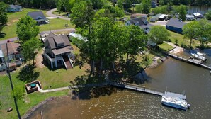 An aerial view of a lakeside community with houses, a dock, and a boat. - Spacious Split-Level Retreat | Sleeps 11 (Saluda County)
