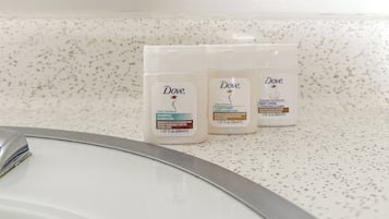 Bañera con ducha, toallas, jabón, shampoo