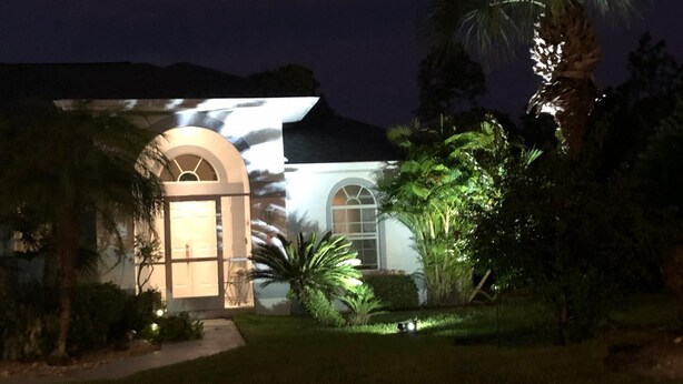 A house with a large arched entrance and a window with a view of the surrounding greenery. - Hibiscus Point - Villa for 4 pers. with large terrace, garden and heated pool (Lehigh Acres)