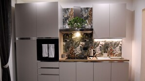 Una cocina moderna con un refrigerador empotrado, una cafetera y un lavamanos.