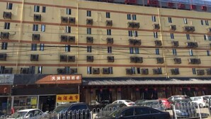 Et hotel med flere etager, balkoner og aircondition.