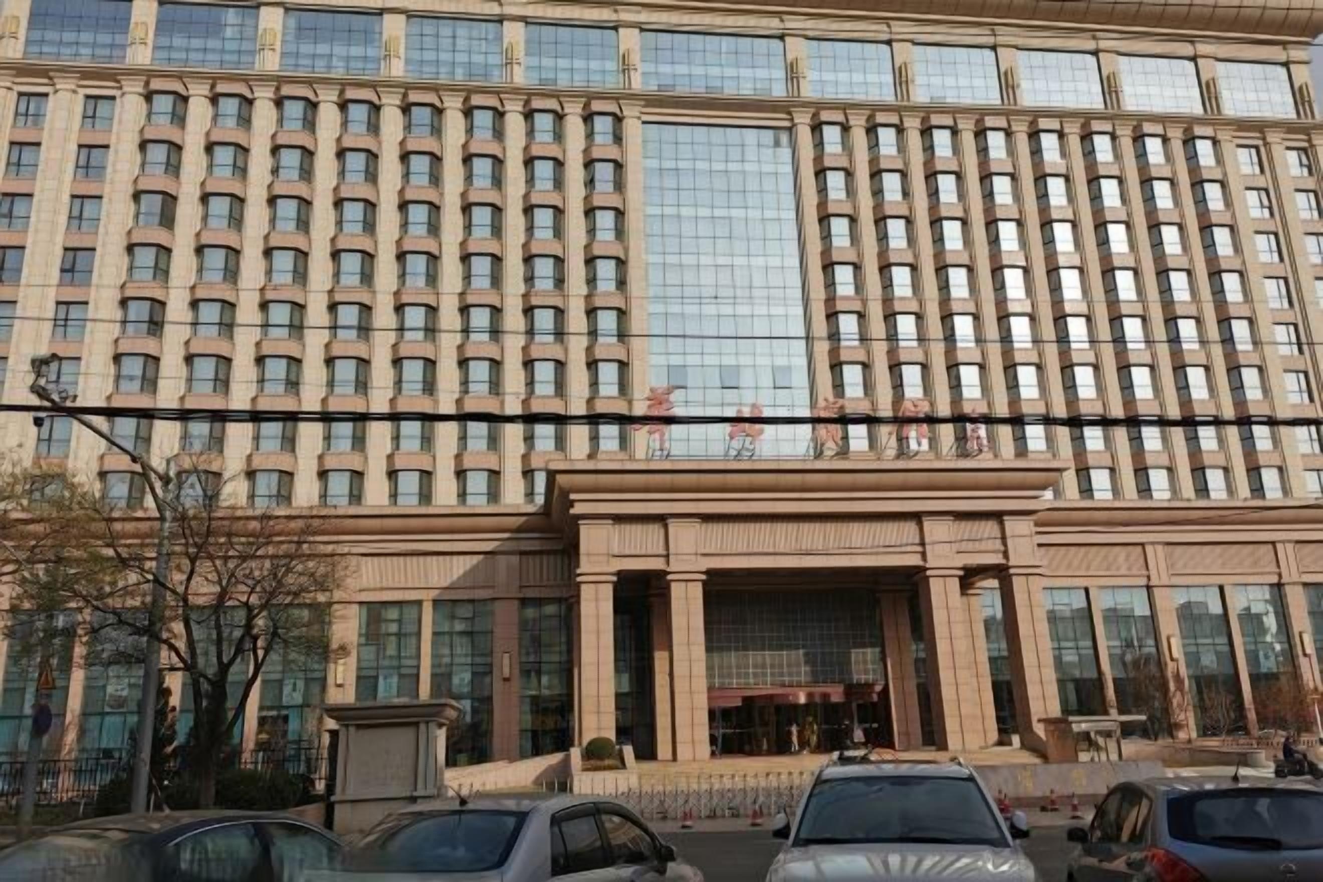 Un edificio de varios pisos con fachada simétrica, ventanas amplias y una entrada central.