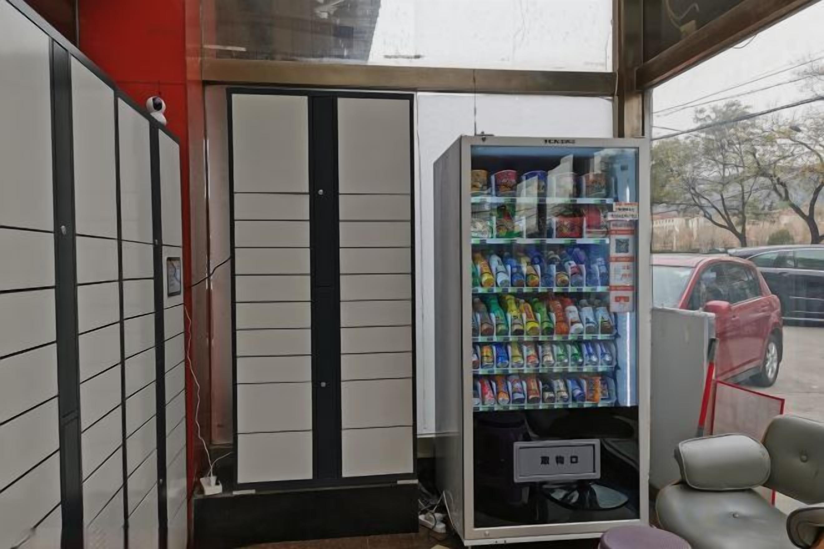 Una máquina expendedora con diversas bebidas y aperitivos, una puerta con un diseño en blanco y negro, y un coche aparcado fuera.