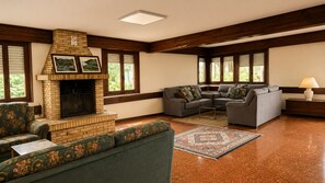 A living room with a brick fireplace, two sofas, a coffee table, and a patterned rug. - Matzuri Nekazal Turismoa (Mutriku)
