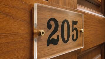 A wooden door with a clear, rectangular sign displaying the number 205.