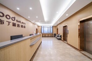 A hotel reception area with a reception desk, seating area, and elevators. - Enjoy Hotel (Wuzhong Road) (Shanghai)
