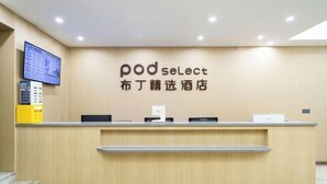 A reception desk with a sign reading "pod select" and a digital display above it. - Enjoy Hotel (Wuzhong Road) (Shanghai)