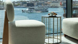 Una sala de estar moderna con vistas a un río y un paisaje urbano.