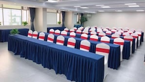 A conference room with rows of tables, chairs, and a projector on the ceiling. - Jingdu Hotel (Quanzhou West Street Overseas Chinese History Museum Branch) (Quanzhou)