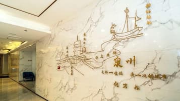 Un muro de mármol con caligrafía dorada e ilustración de un pagode.