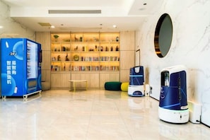 A hotel lobby with a vending machine, a bookshelf, and a coffee machine. - Jingdu Hotel (Quanzhou West Street Overseas Chinese History Museum Branch) (Quanzhou)