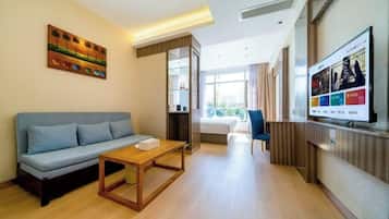 A modern living room with a sofa, coffee table, and a flat-screen TV mounted on the wall.