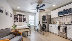 Eine kompakte Küche mit Deckenventilator, Waschmaschine und Backofen.