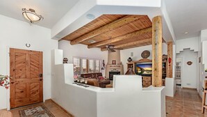 Ein geräumiger Wohnbereich mit Kamin, Fernseher und Holzboden.
