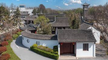 A traditional building with curved roofs and a small entrance, surrounded by well-maintained greenery.