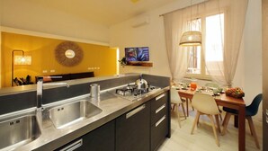 A modern kitchen with a central island, stainless steel appliances, and a dining area with a table and chairs.