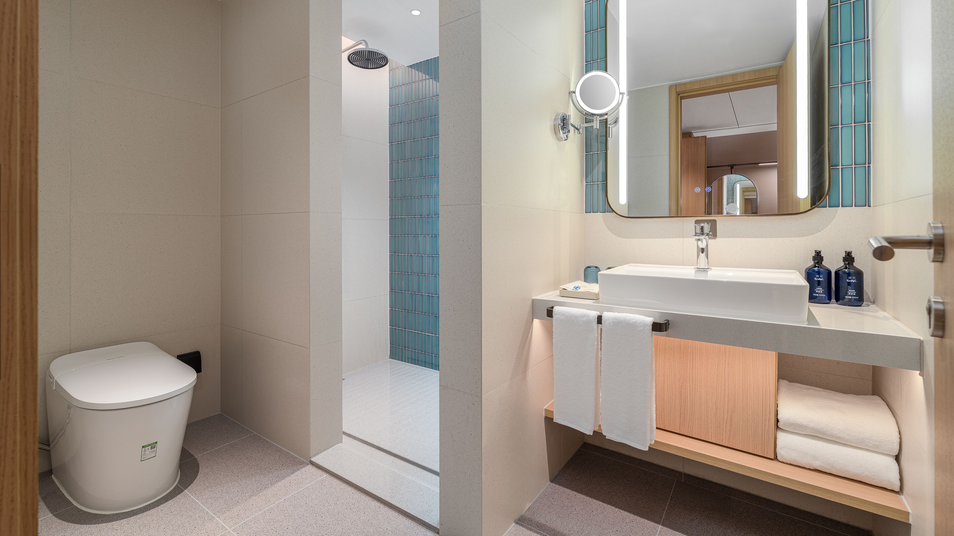 A modern bathroom with a toilet, sink, and shower area.