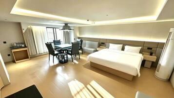 A modern hotel room with a large bed, a desk, and a chair.