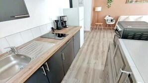 Une cuisine moderne dotée d’un plan de travail en bois, d’un évier en acier inoxydable et d’une machine à café.