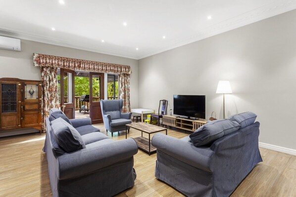 A living room with two grey sofas, a coffee table, a TV, and a lamp.