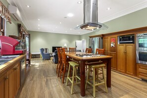 A spacious kitchen with wooden cabinets, a stainless steel range hood, and modern appliances.