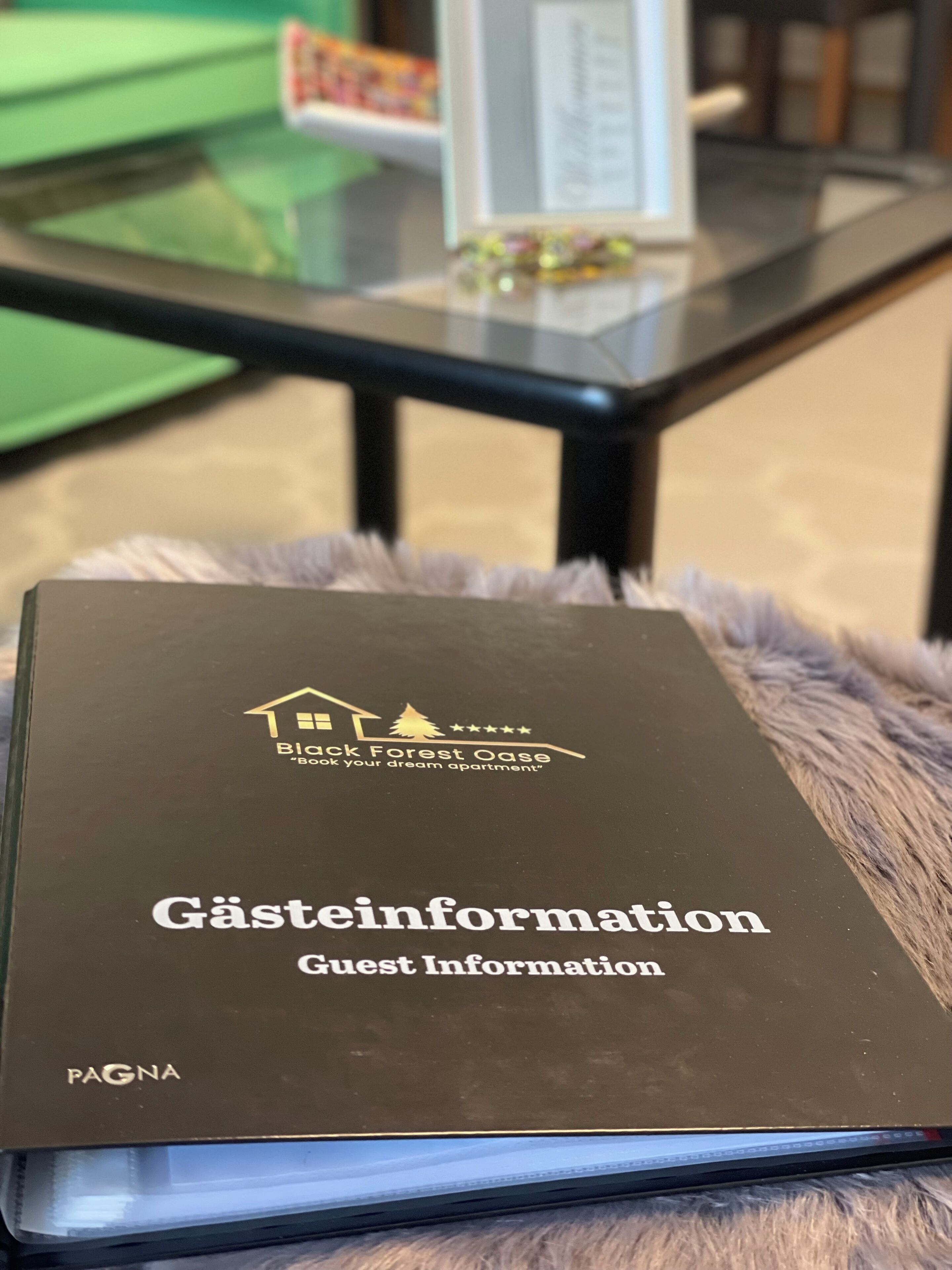 Un folleto informativo para huéspedes con el título 'Gästeinformation', un logotipo y texto que indica que es para Black Forest Oase.